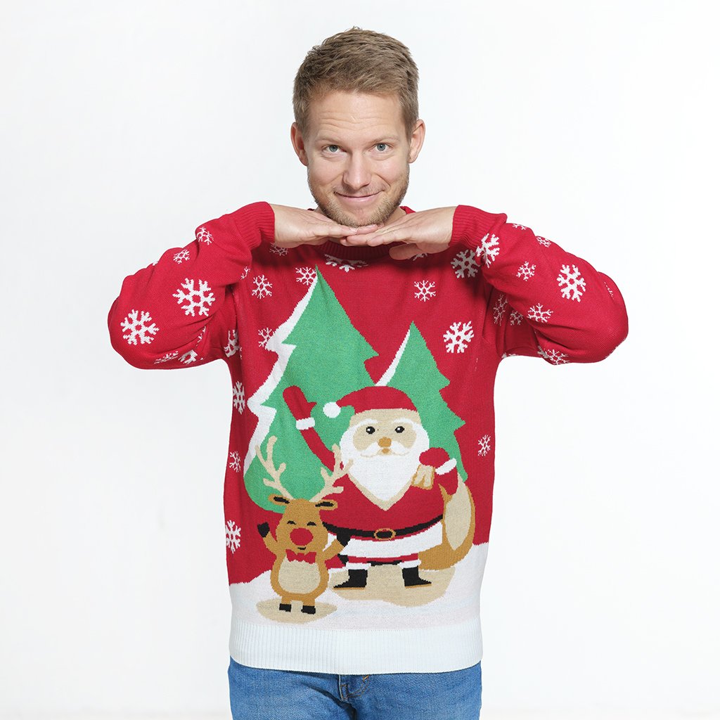 En mand smiler og er iført en rød julesweater med snefnug på.